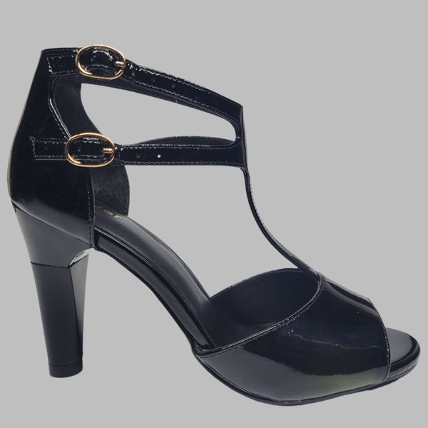 Black heeled women's shoe closeup side view. Featuring shock-absorbing heel and buckled strap for a comfortable wear.